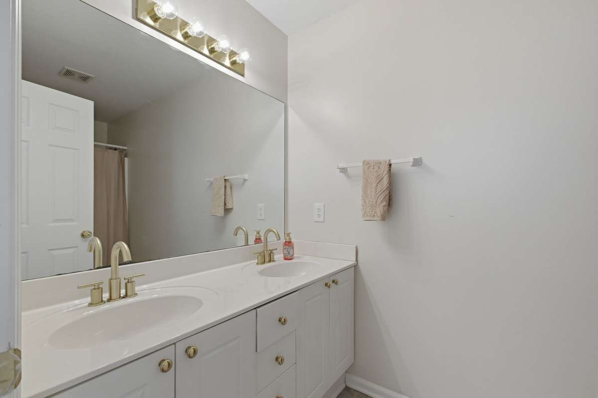Primary Bathroom has double vanities with updated hardware and a shower/tub combo