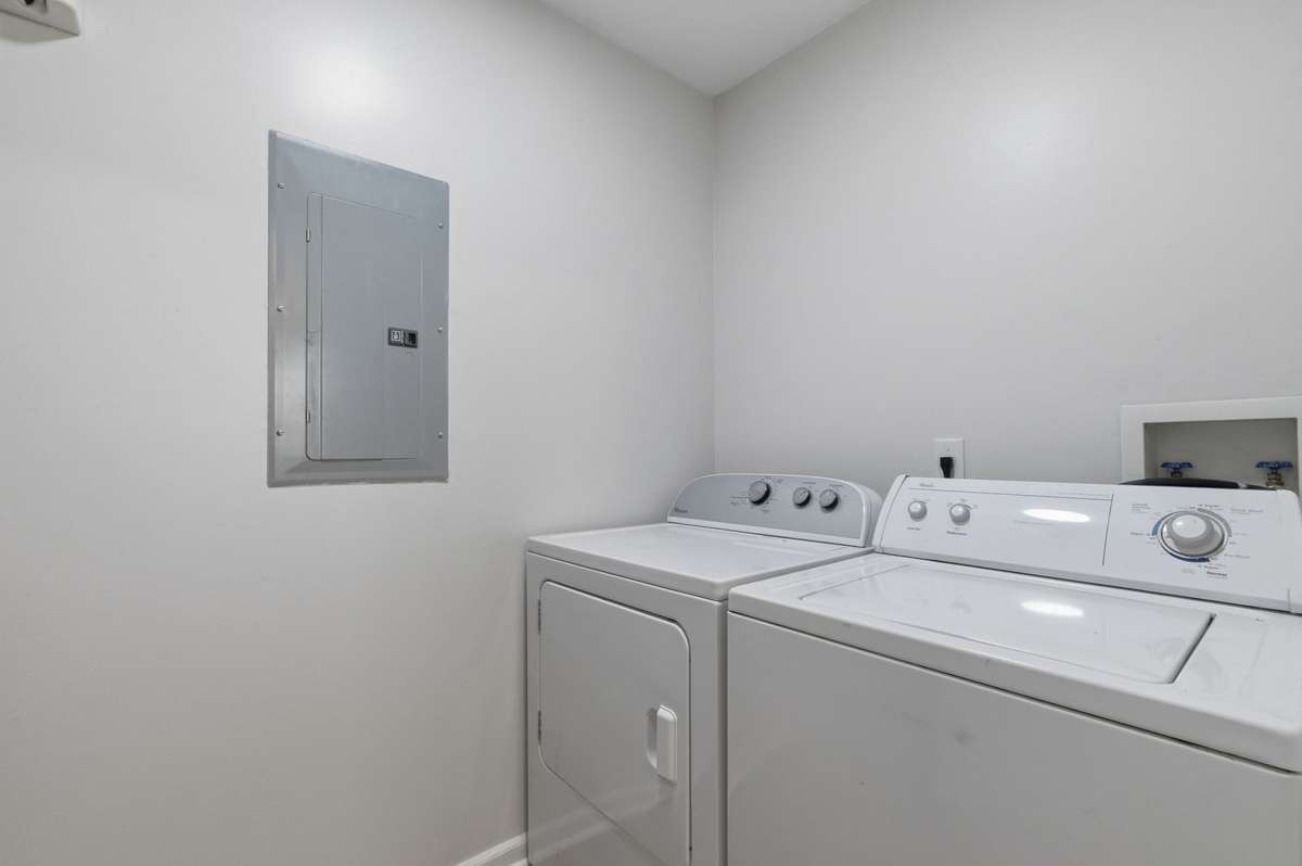 Laundry room/utility room is positioned conveniently next to the kitchen and also houses the water heater and a kitchen panty