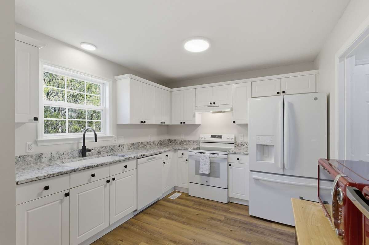 The recently updated kitchen now boasts beautiful and durable granite countertops, new appliances matte black hardware