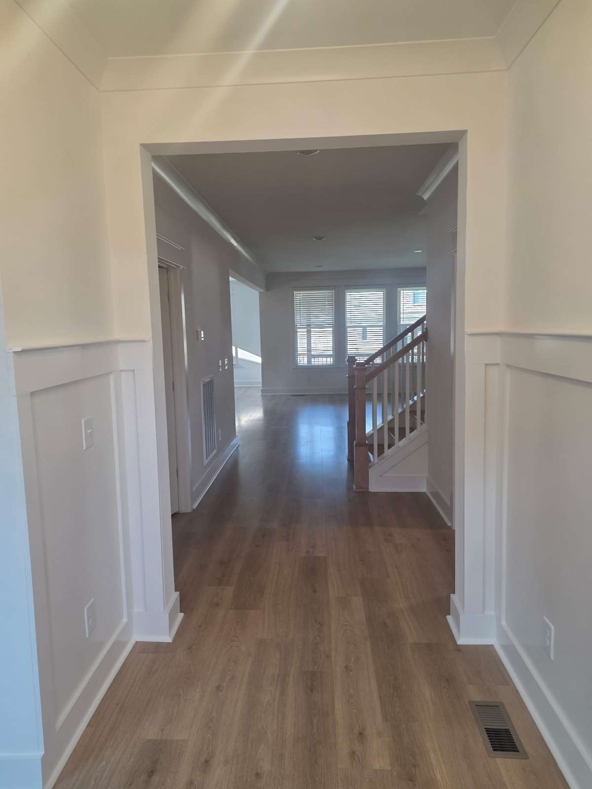 Foyer with judges paneling and laminate plank flooring