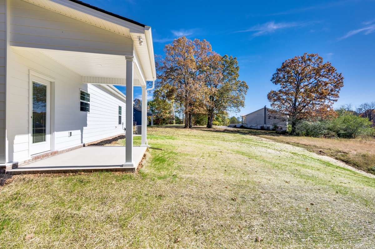 A view overlooking the back patio, which features a covered area and a large open yard.