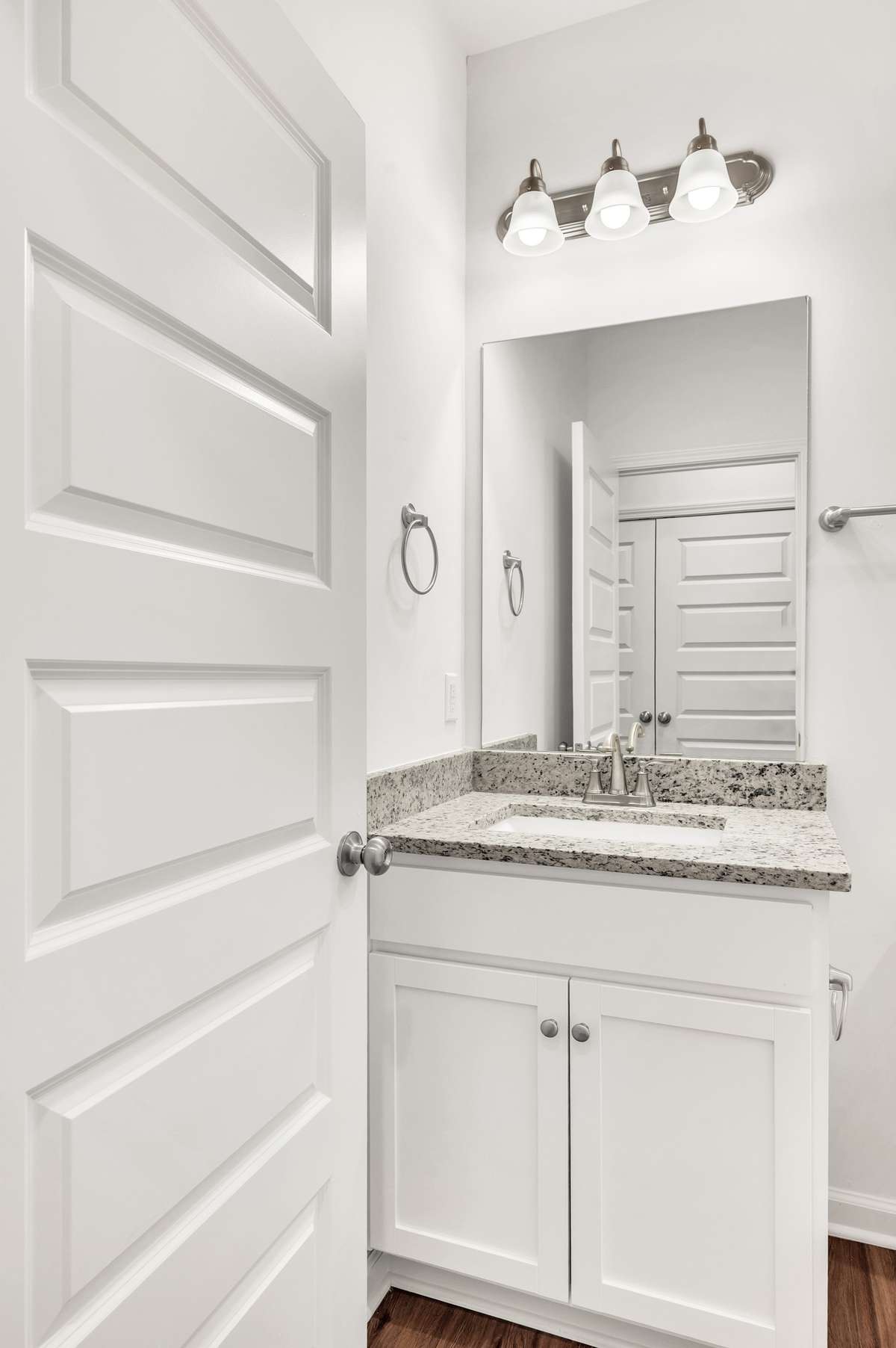 Crisp and clean vanity space featuring granite countertops, brushed nickel fixtures, and bright lighting—perfect for a polished morning routine.