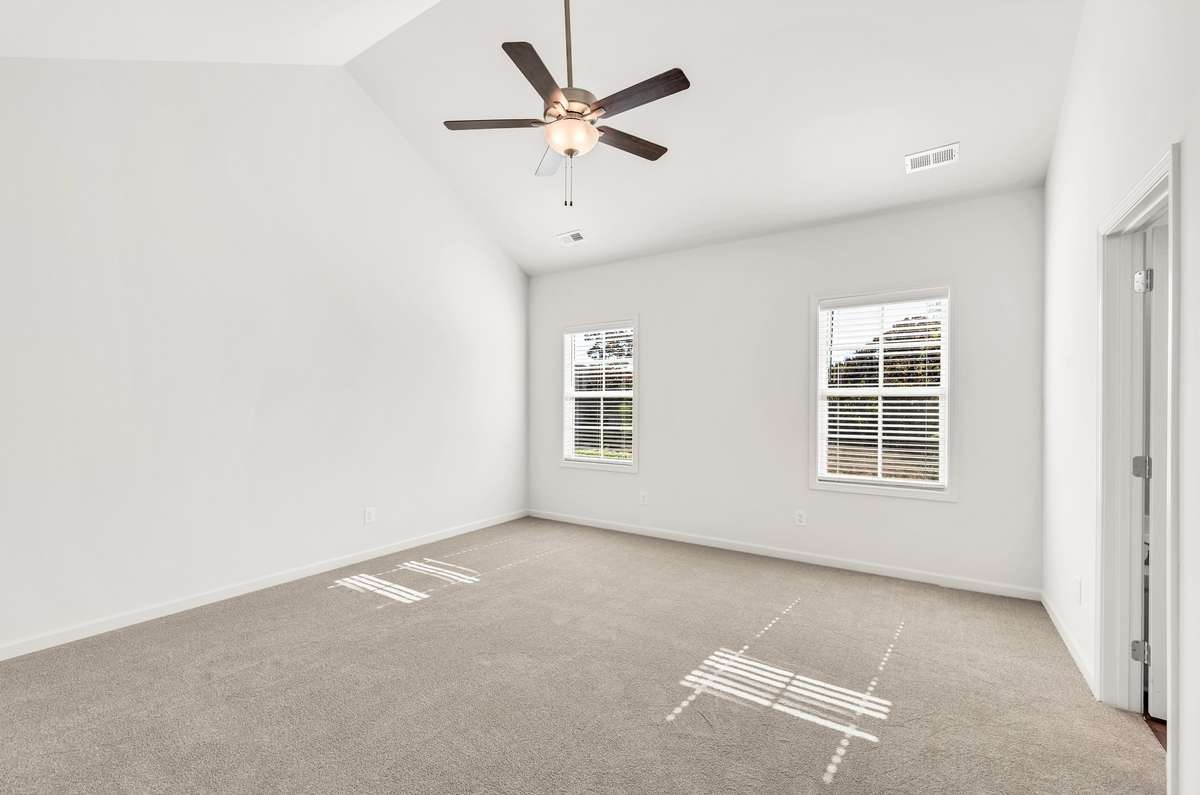 An expansive bedroom suite enhanced by vaulted ceilings, giving the room a bright, airy feel.