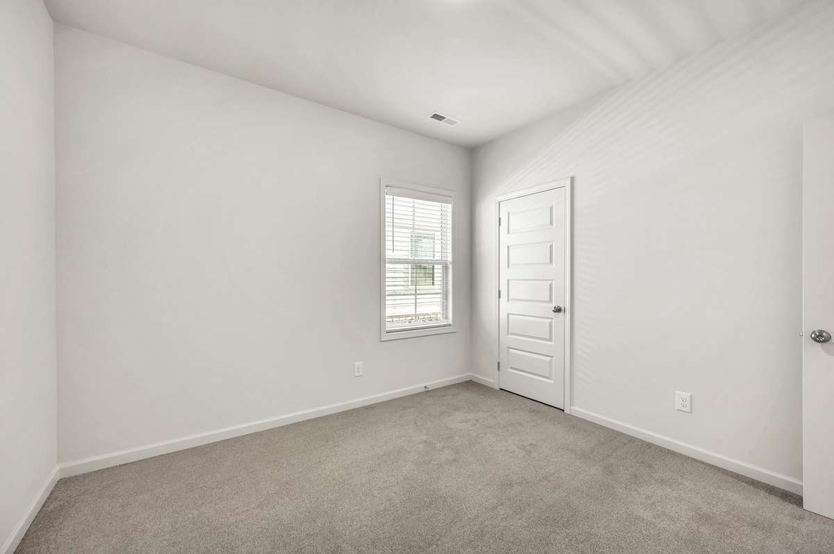 Bright and versatile bedroom with soft carpet, a spacious closet, and a window bringing in natural light
