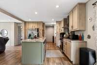View from dining area into kitchen and into the combination coffee bar/utility room/panty rooms.