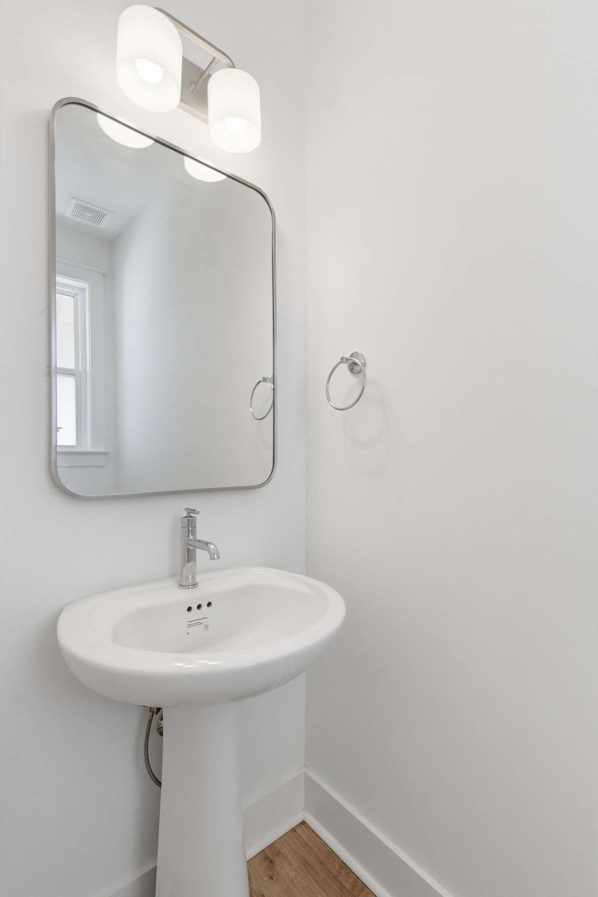 Convenient main-floor powder room half-bath with a pedestal sink.