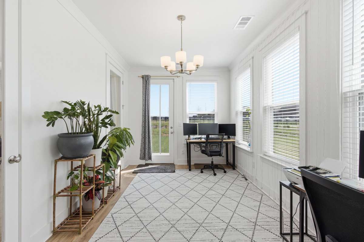 Sun-drenched main-floor office or Florida room surrounded by walls of windows.