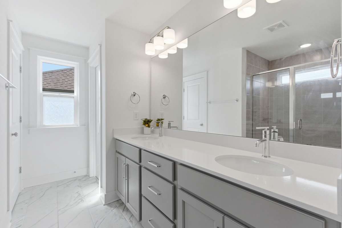 Spa-like primary en-suite bathroom boasting a large double vanity with quartz countertops.