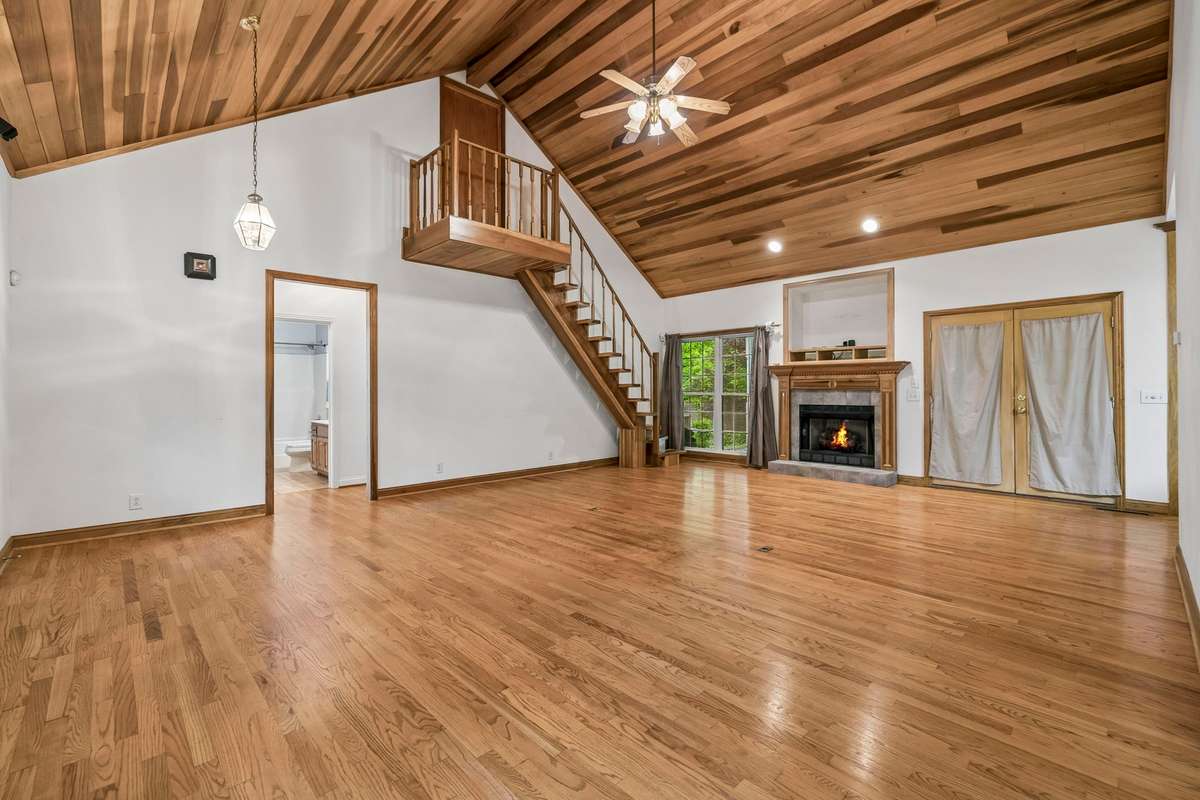 Custom built stairs lead to an office upstairs with a built-in desk and extra large closet/storage space.