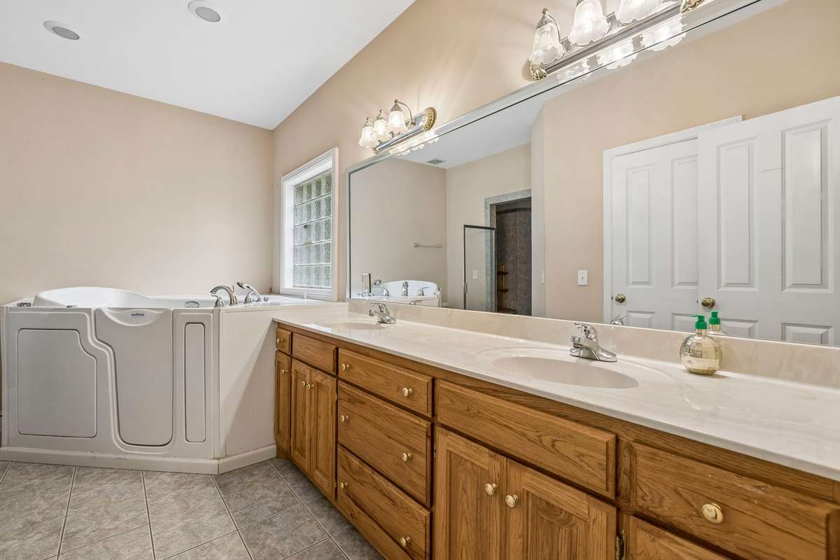 Newer walk in tub and double vanities in the primary en suite.