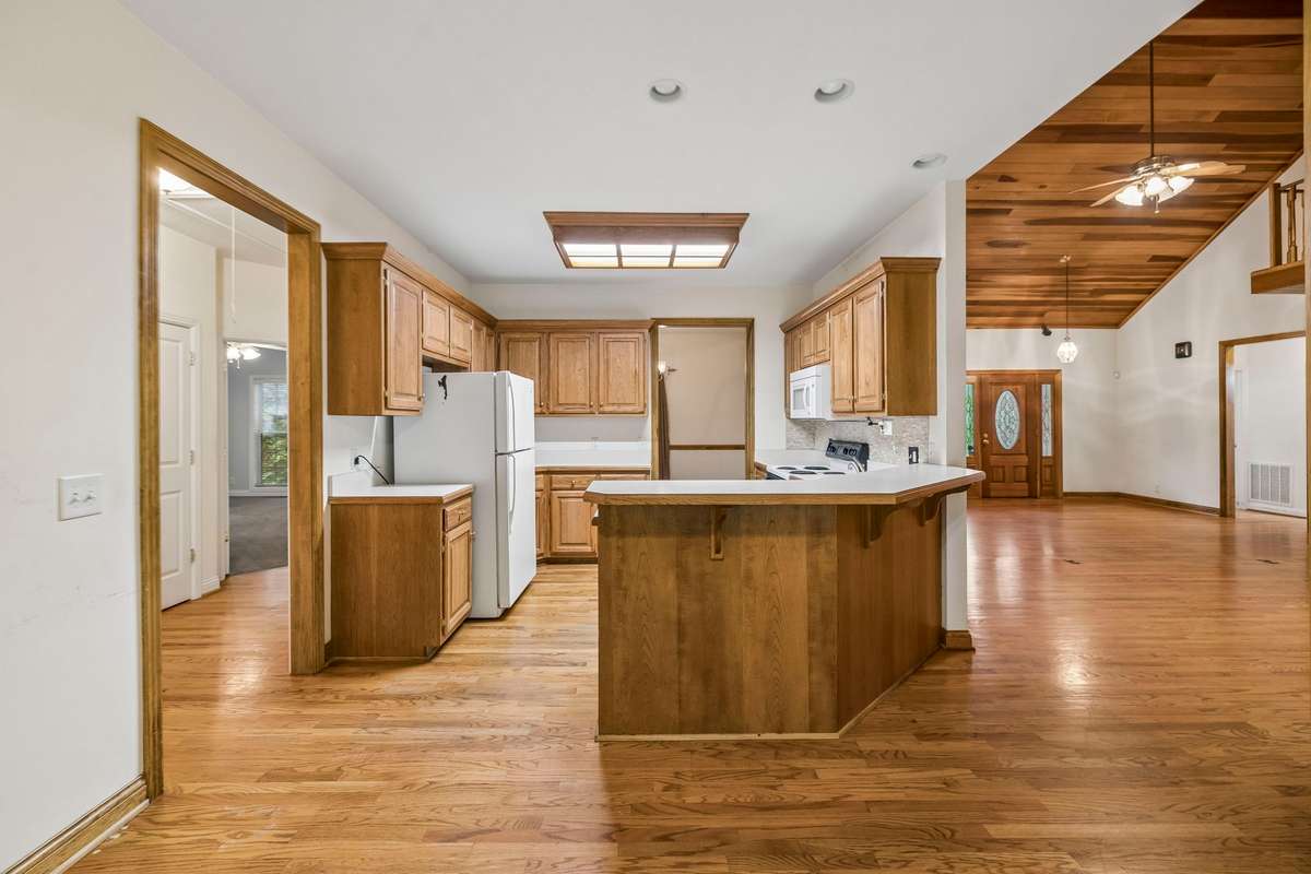 Open kitchen with tons of potential. Beautiful custom cabinetry could easily be upgraded with new hardware and fixtures.
