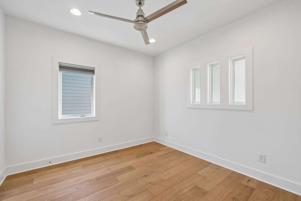 This bedroom features a custom interior window cutout, facing the sunlit foyer.