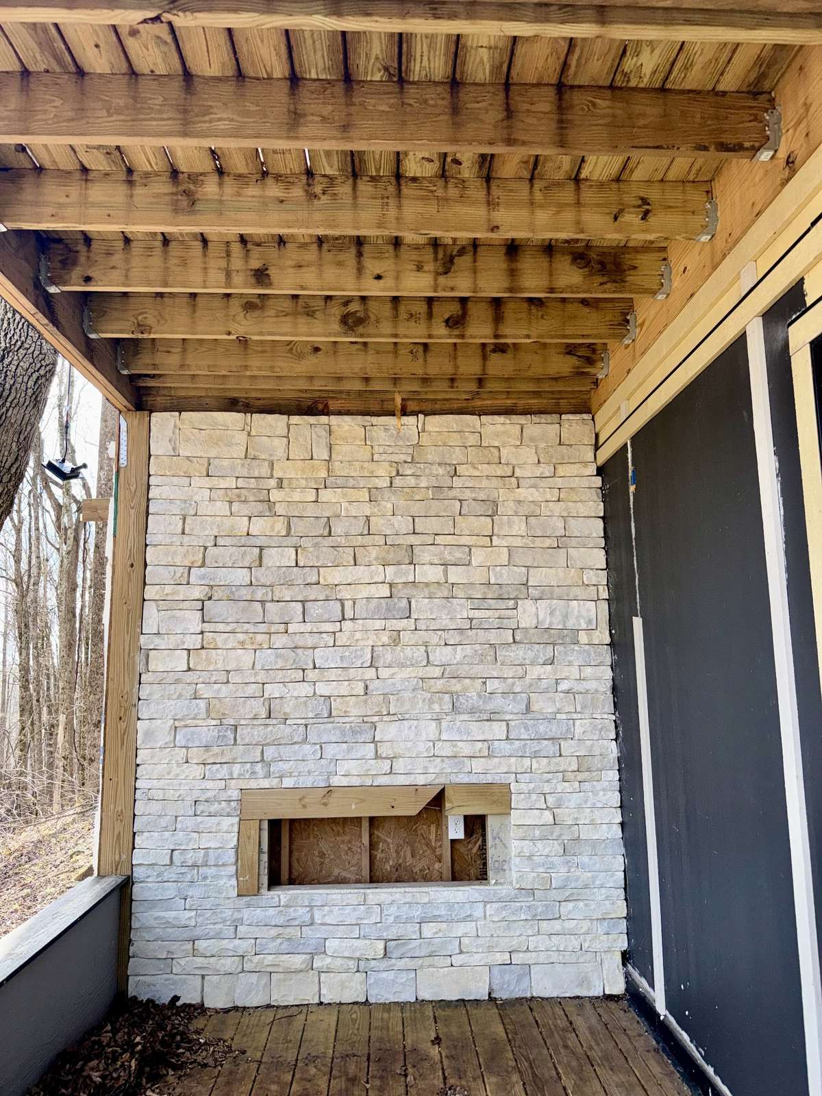 An unfinished stone fireplace serves as a stunning focal point, ready to be completed to create a cozy atmosphere for warm evenings spent under the stars.
