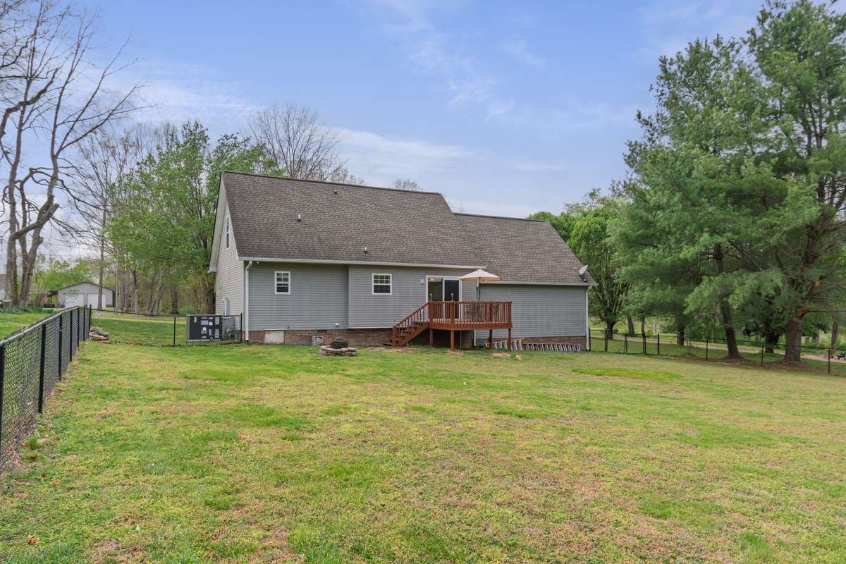 Take in the generous green space and wooded backdrop that make this yard feel open and inviting.