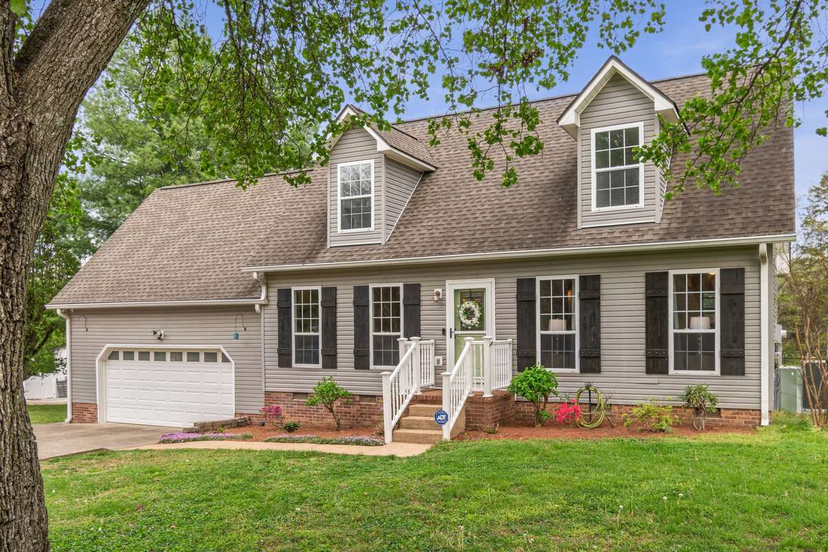 A closer look at the inviting front entry highlights the warm, cottage-inspired character and landscaped touches.