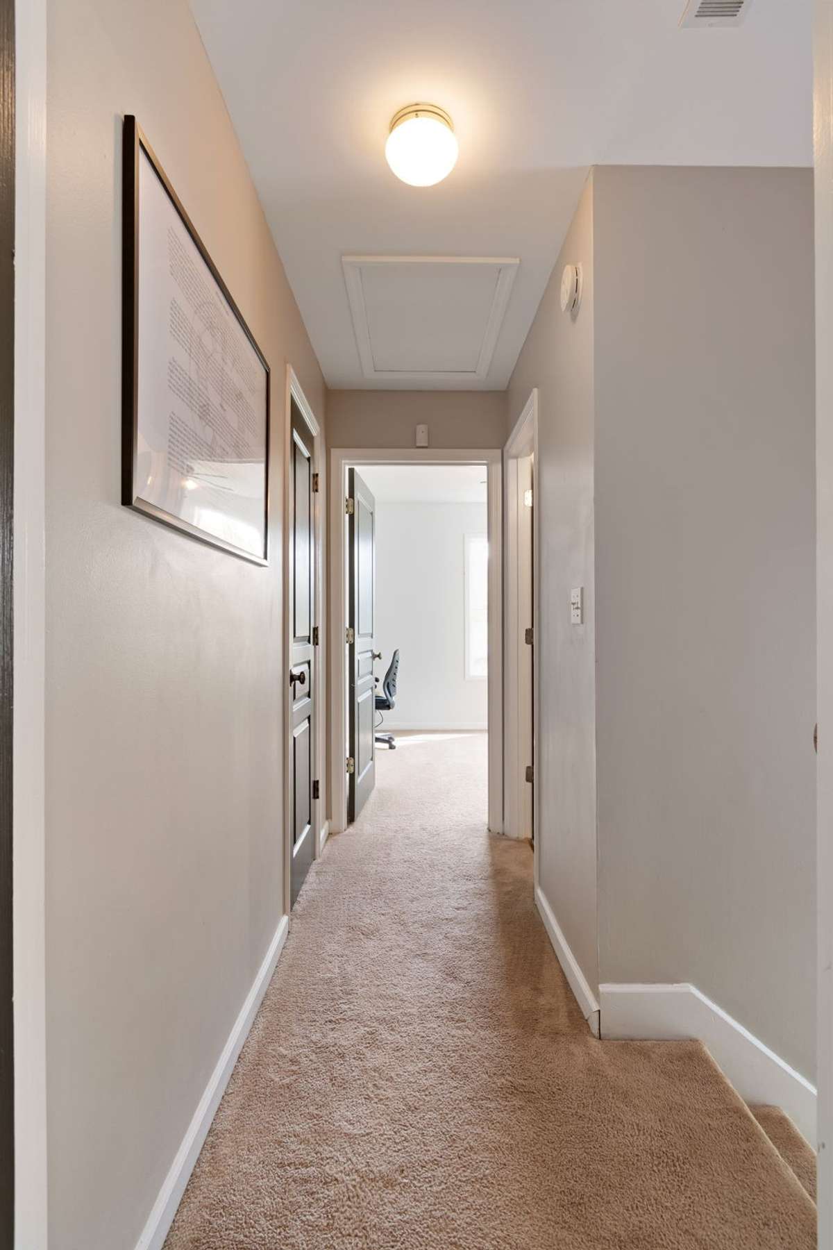 Upstairs, a bright hallway leads to the bedrooms and bath, creating a calm and functional transition space.