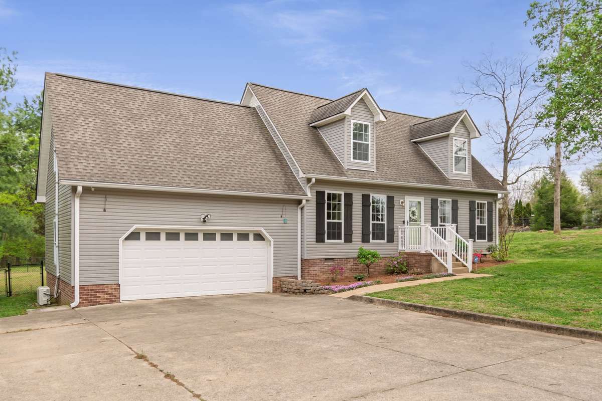 The wide driveway offers plenty of parking and an easy approach to the attached garage and front steps.