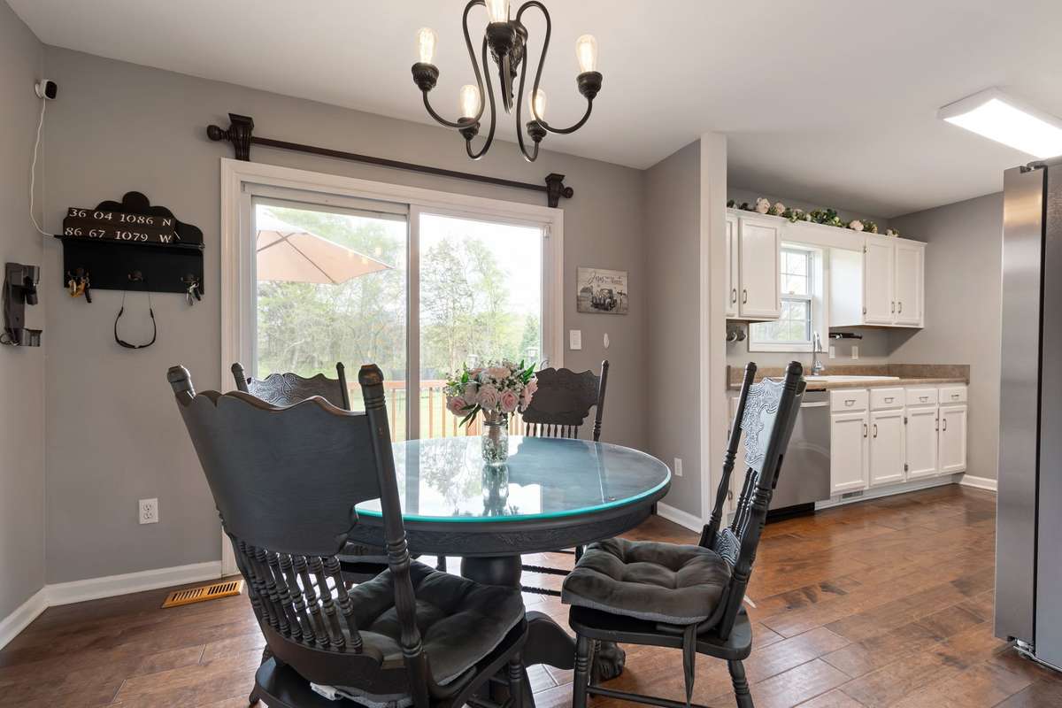 The dining nook sits beside the kitchen, with white cabinetry, updated lighting, and easy access to the deck for effortless hosting.
