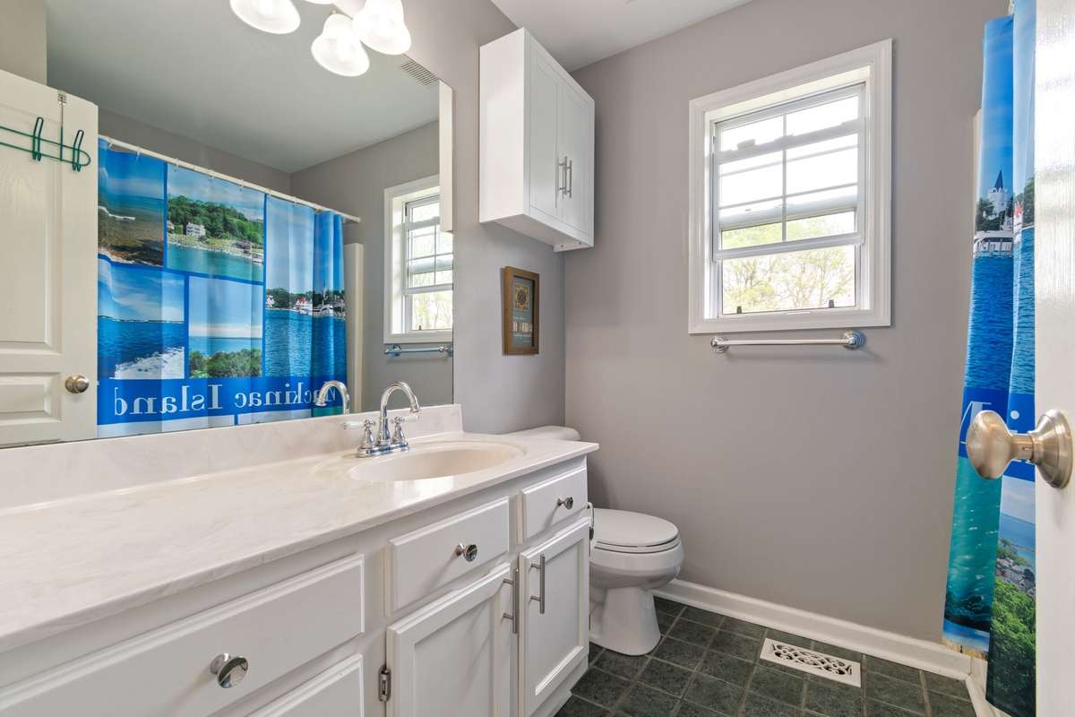 A roomy vanity, window for natural light, and a shower/tub combo make this space both functional and cheerful.