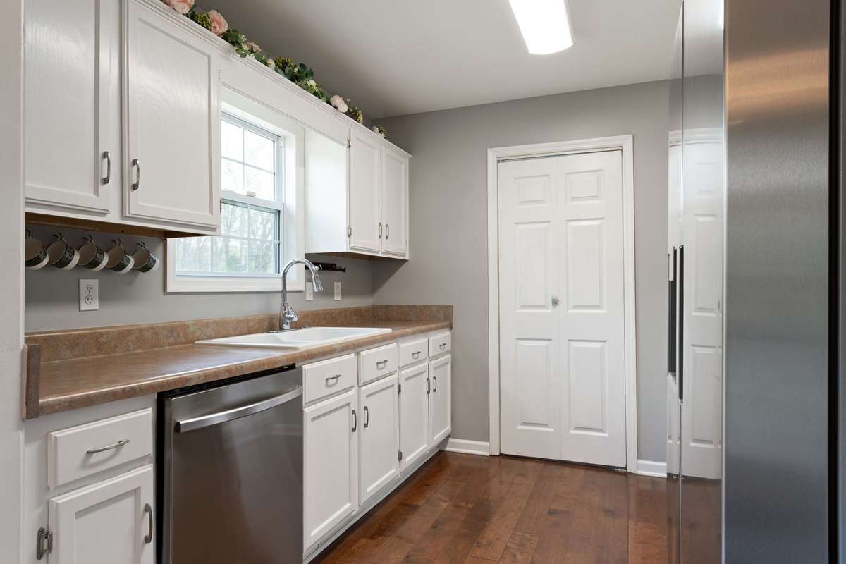 The bright, functional kitchen offers plenty of cabinet space and a clean layout that makes everyday cooking feel effortless.