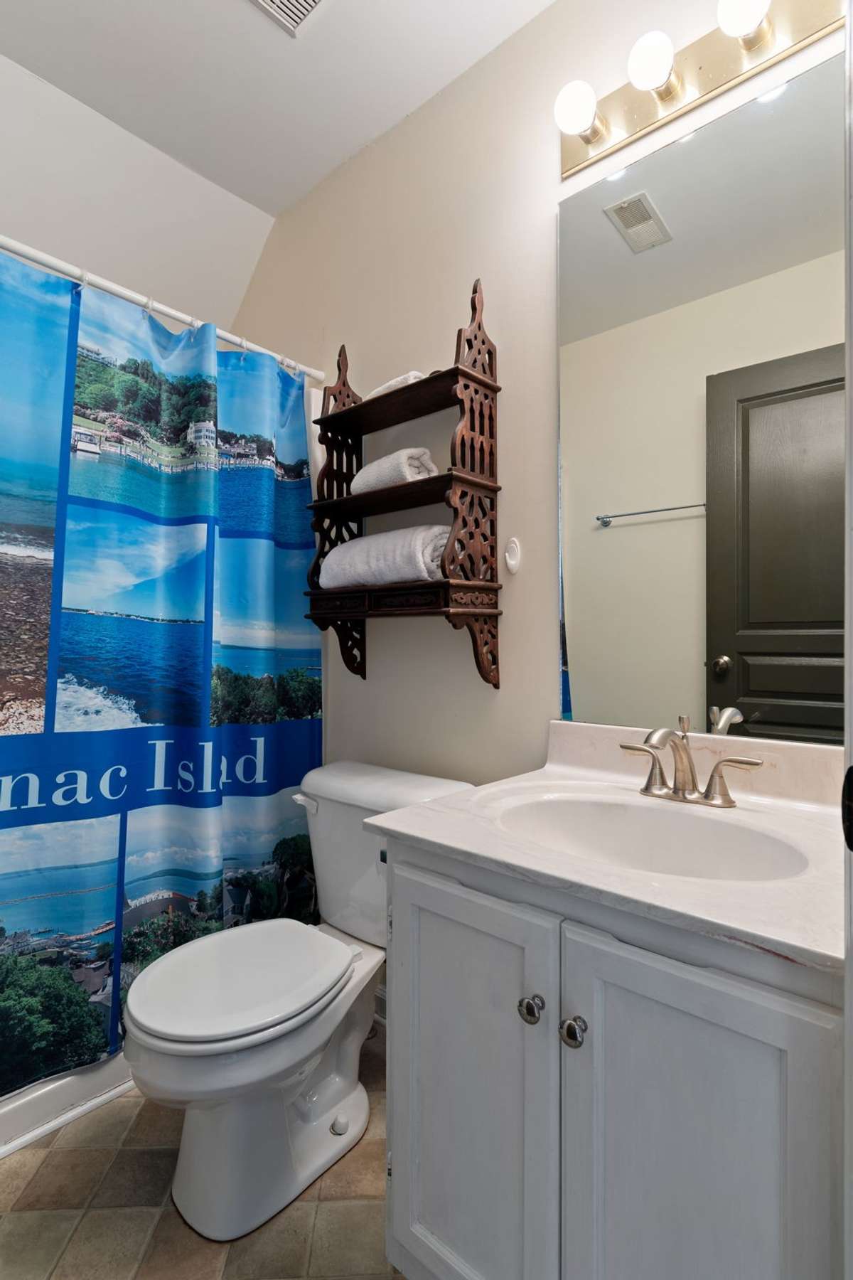 This cheerful full bath offers a bright vanity, great lighting, and necessary storage space for guests or everyday use.