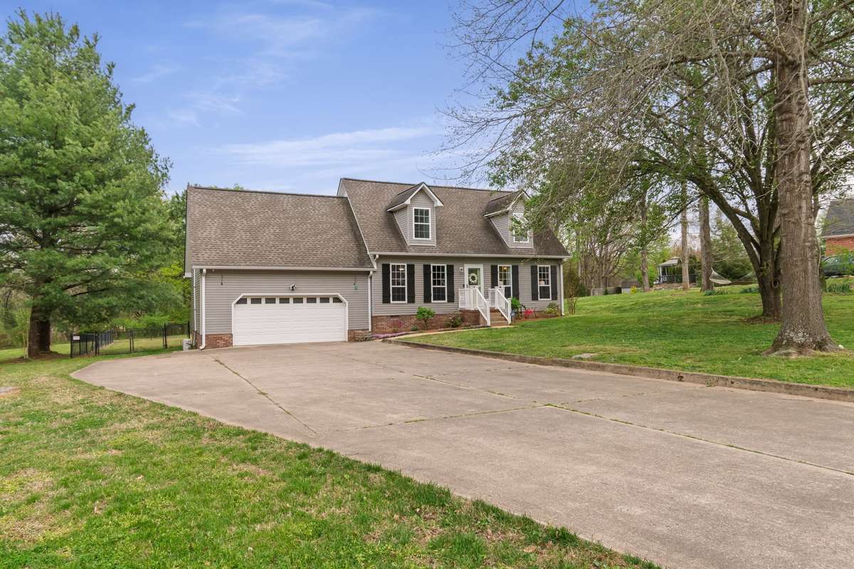 This view showcases the home’s timeless lines, spacious driveway and yard space, and comfortable everyday access.
