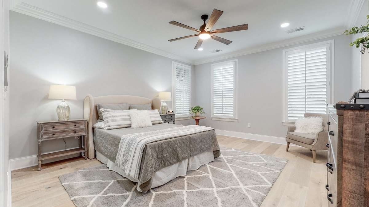 Primary Bedroom features 9 foot ceiling, new hardwood floors, new paint and plantation shutters