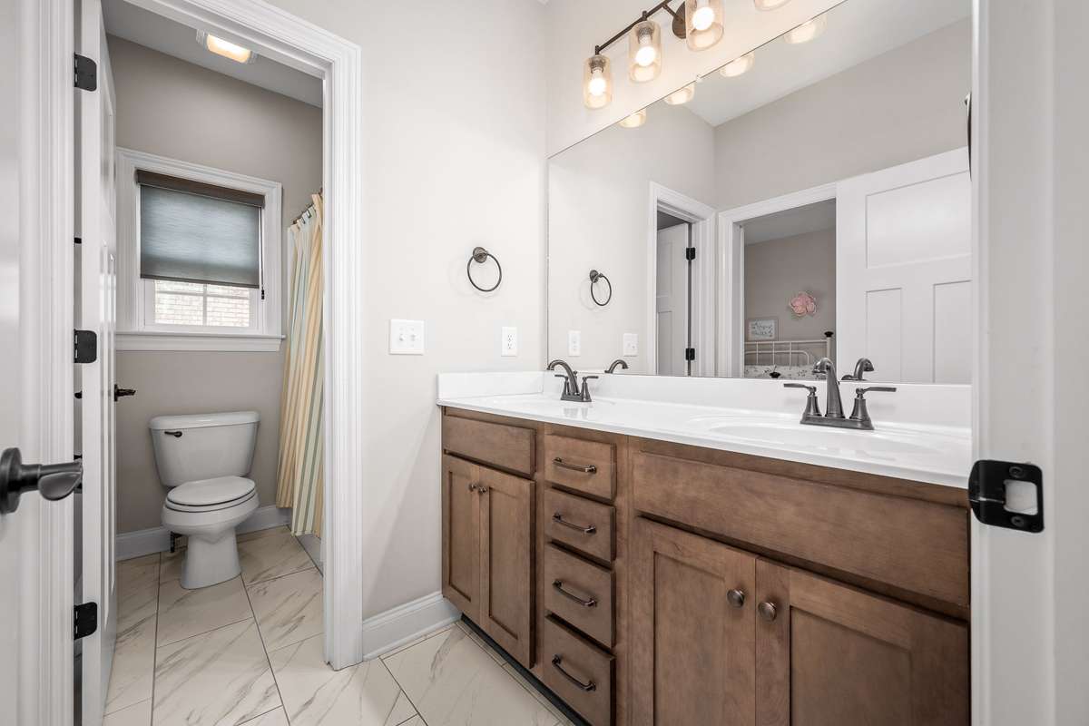 Full bathroom with separate shower area.  Double sinks services both guest bedrooms with one doorway into bedroom 2. Comfort height vanity and tile floors create a updated high end feel.