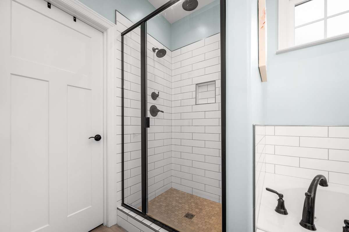 Separate fully tiled shower features multiple shower heads to enhance your experience.