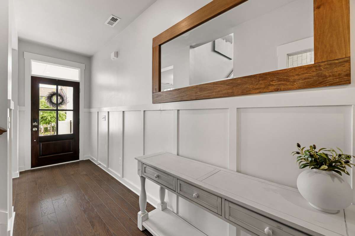 Your guests will appreciate an entry of hardwood floors and custom molding. The wood and glass door brings in added light