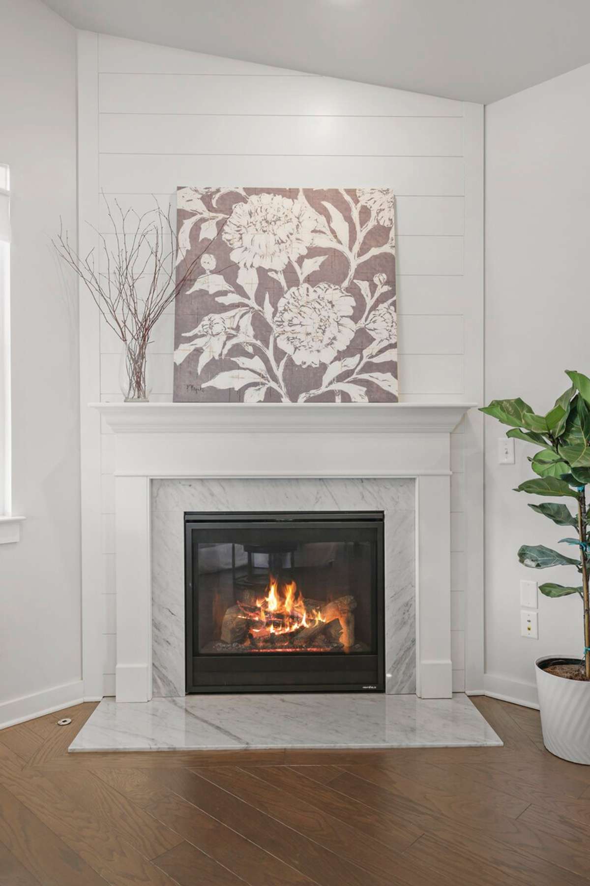 The gas fireplace is enhanced by  marble and ship lap surround