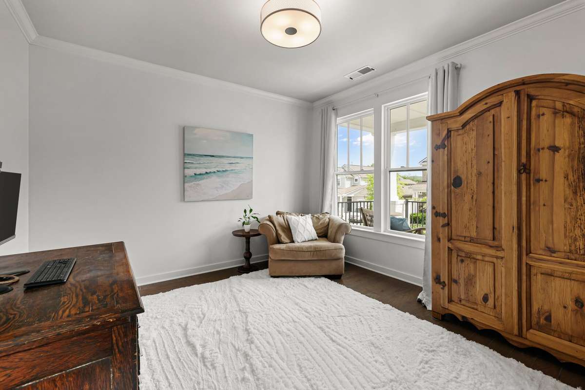 The office overlooks the front porch -boasting hardwood floors, large windows and on trend lighting