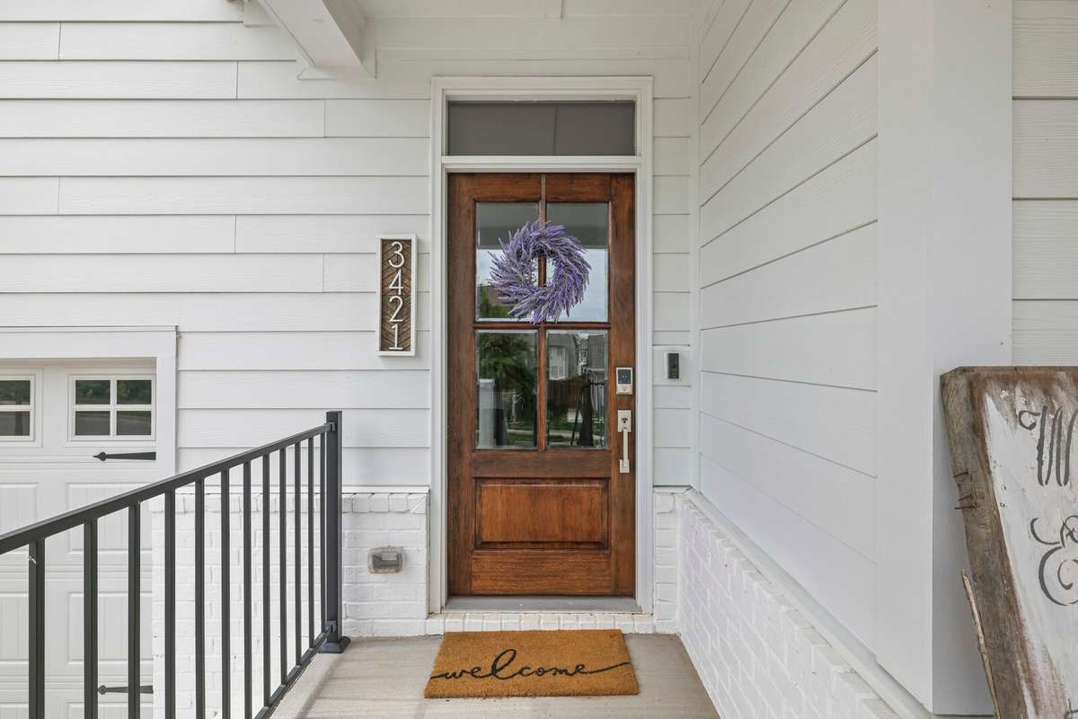 Beautiful wood stained door on covered porch welcomes your guests in. This was an upgrade by the owners