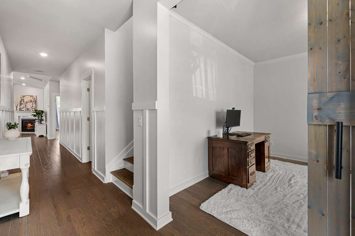 Off to the right is a dedicated home office with wooden barn door closure