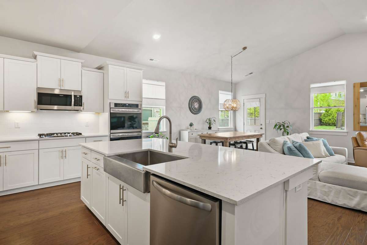 White counters, cabinets and stainless steel appliances give the space a clean, crisp aesthetic