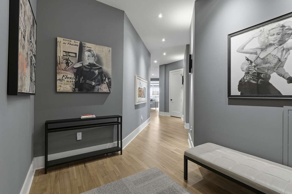 Spacious interior hallway with gallery-style walls and designer lighting.