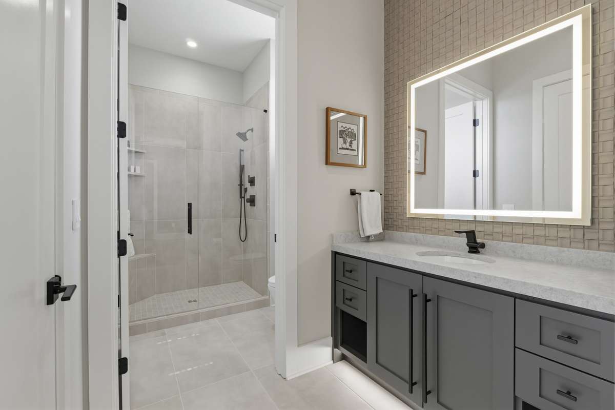 Well-appointed full bath connecting both secondary bedrooms, featuring custom tile & fixtures.