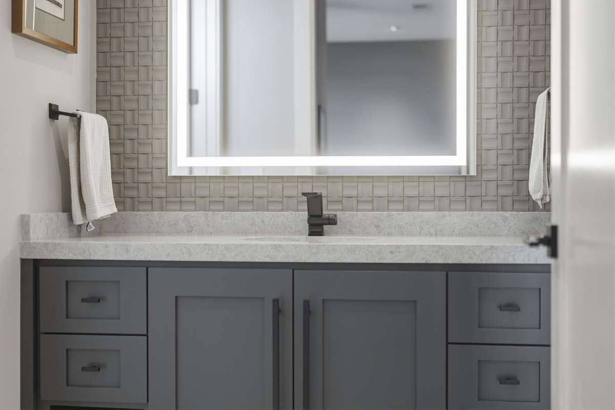 Full bathroom with lighted mirror, custom cabinetry, and modern finishes.