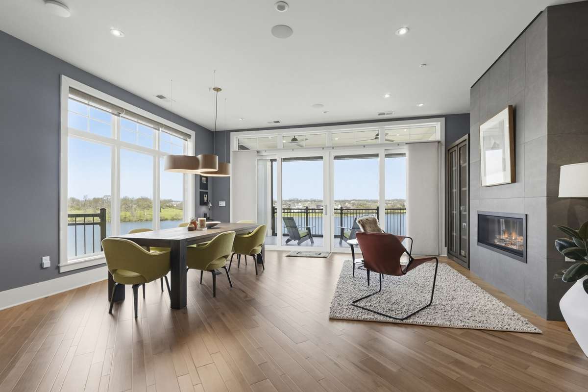 Open dining space flows seamlessly into living area with modern fireplace and lake views.