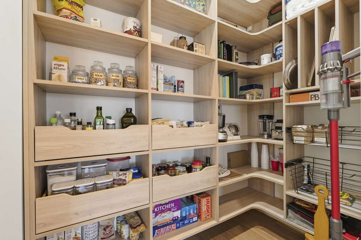 Custom walk-in pantry with built-in shelving offering exceptional storage and organization.