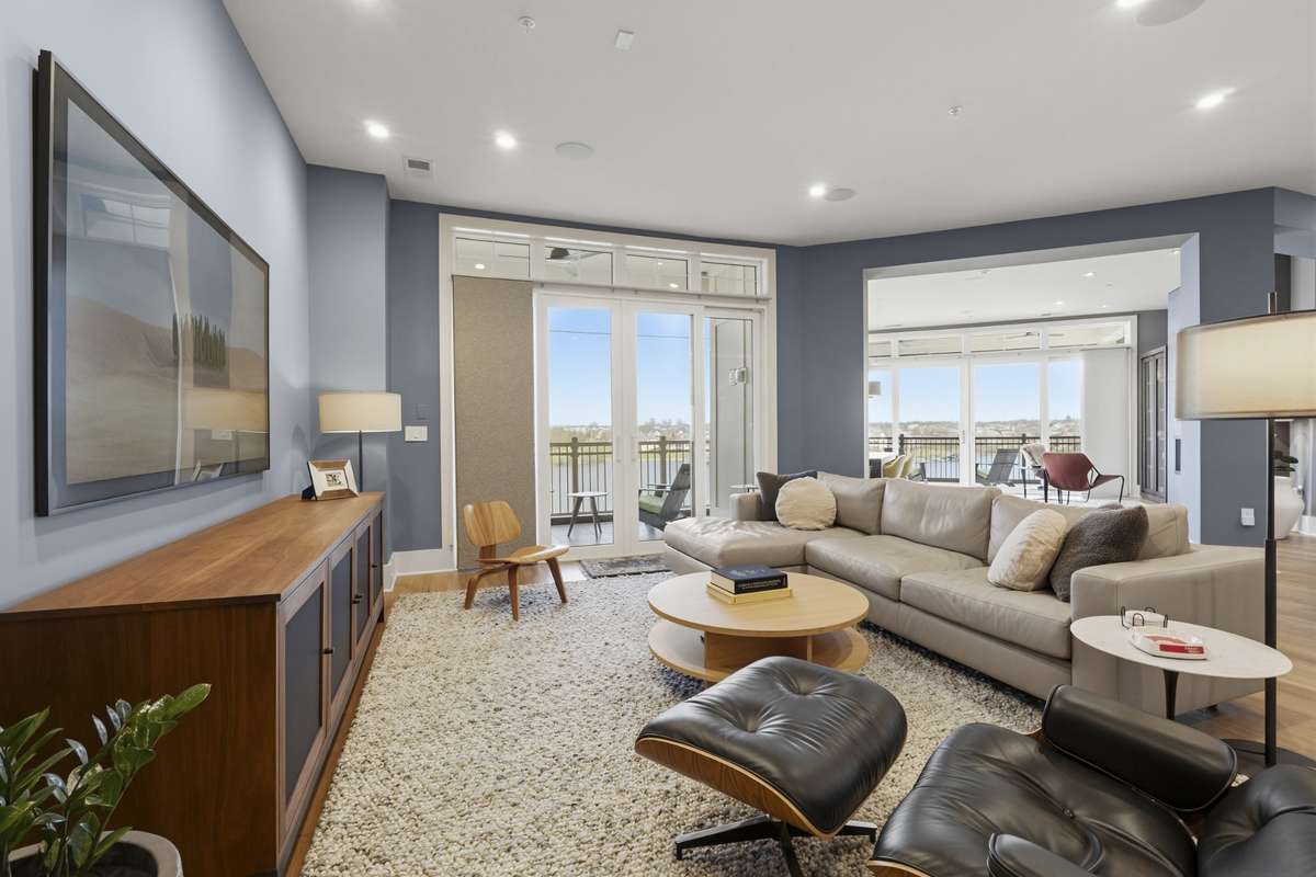 Open-concept living filled with natural light and direct access to lakefront balcony views.