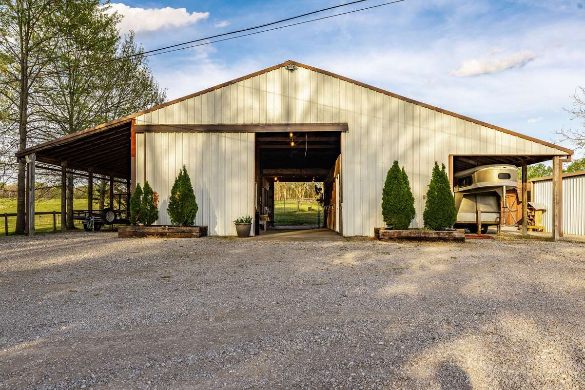 Impressive 50x60 4 stall barn featuring a feed room, tack room, wash bay, trailer storage plus a full efficiency apartment that could be used as a caretaker/guest apartment or you could even use it for income producing.