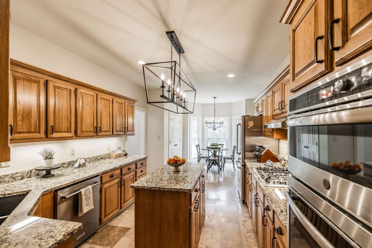 The large kitchen offers lots of cabinet and counter space, including a preparation island, granite countertops and stainless steel appliances.