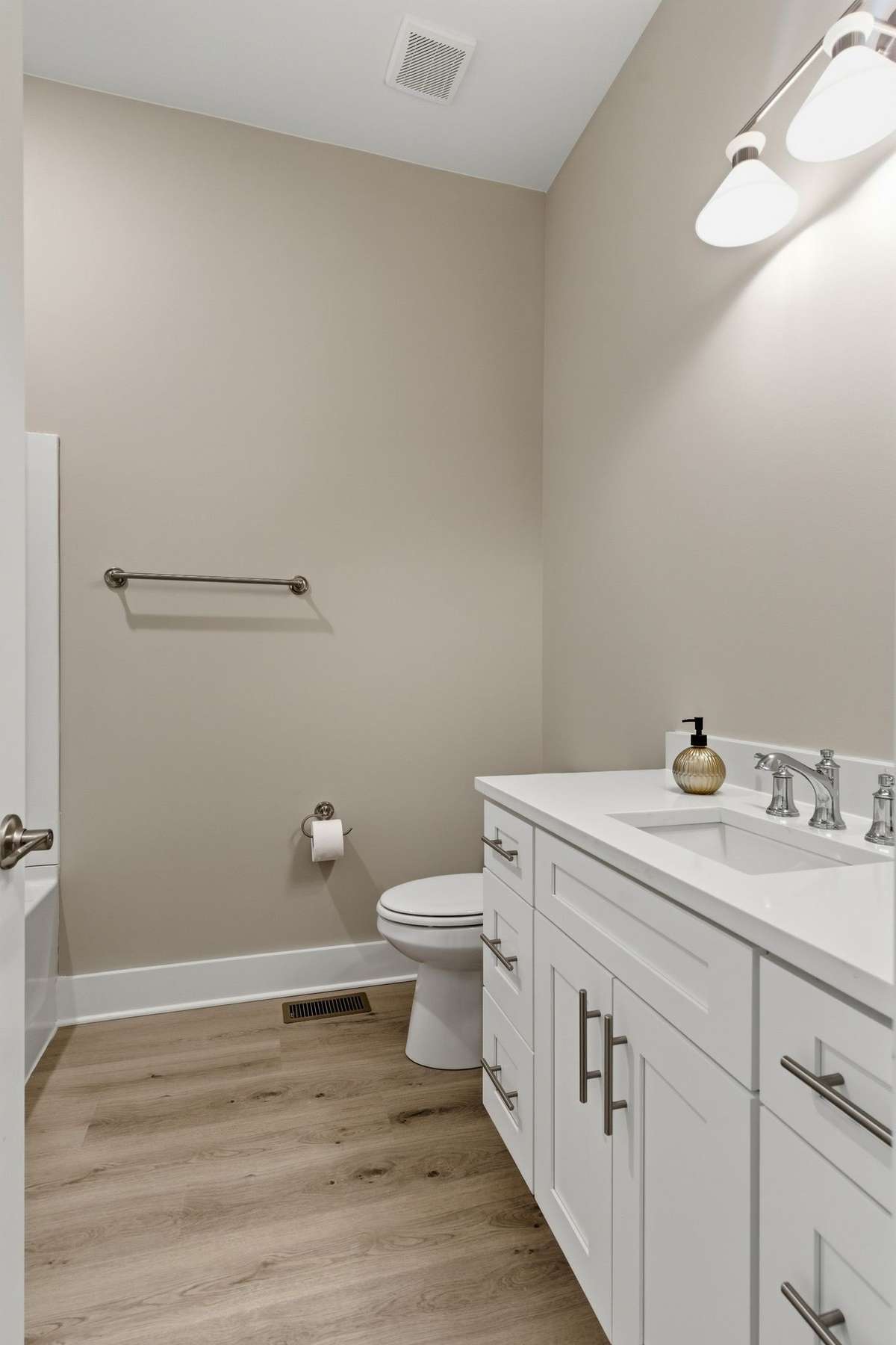 The first floor guest bath has quartz counters.