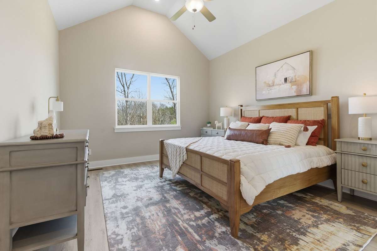 The  first floor primary bedroom has  a vaulted ceiling and a great view.