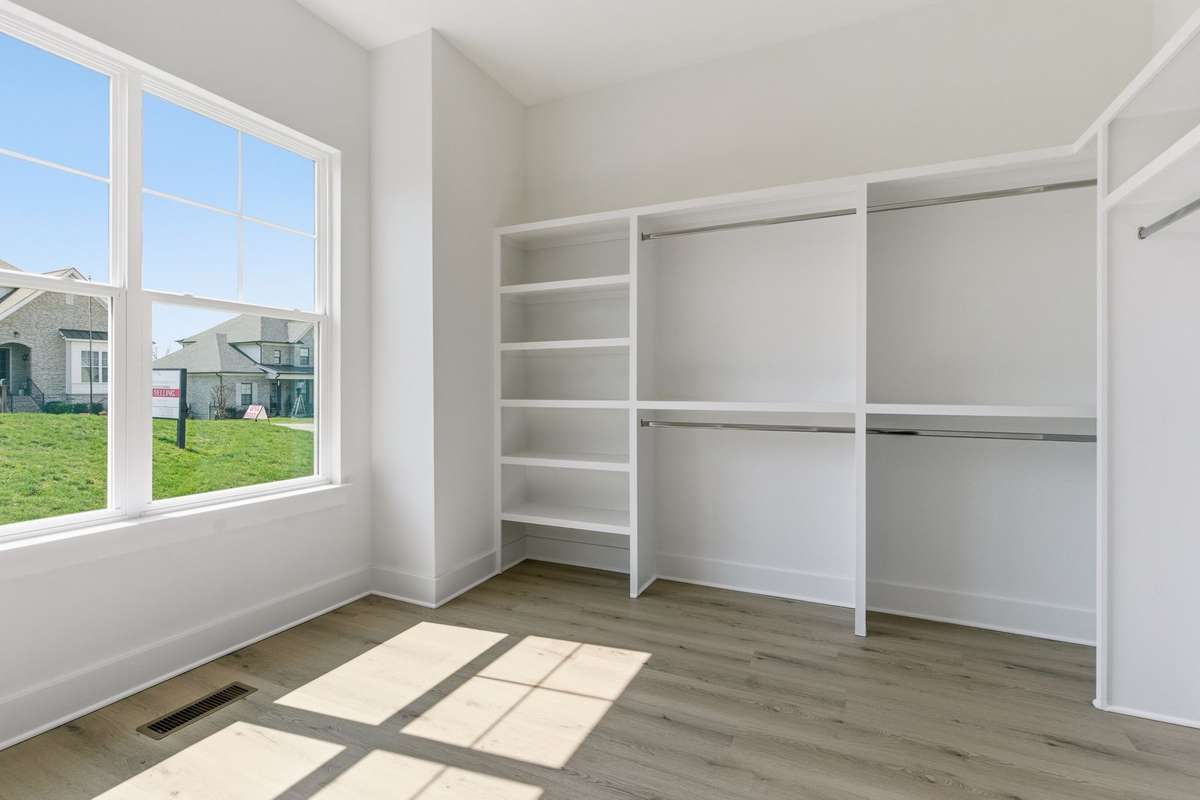 A huge primary suite closet with custom wood shelving completes the primary suite.
