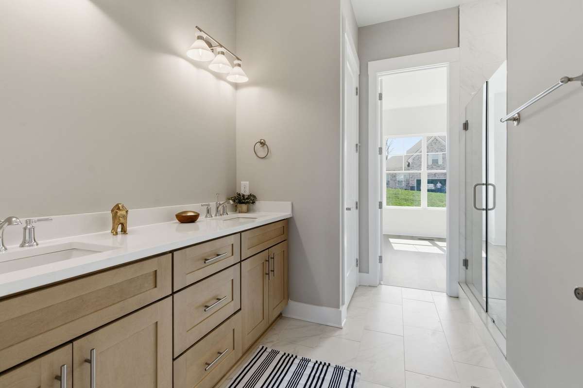 The en-suite primary bath has double sinks and quartz countertops