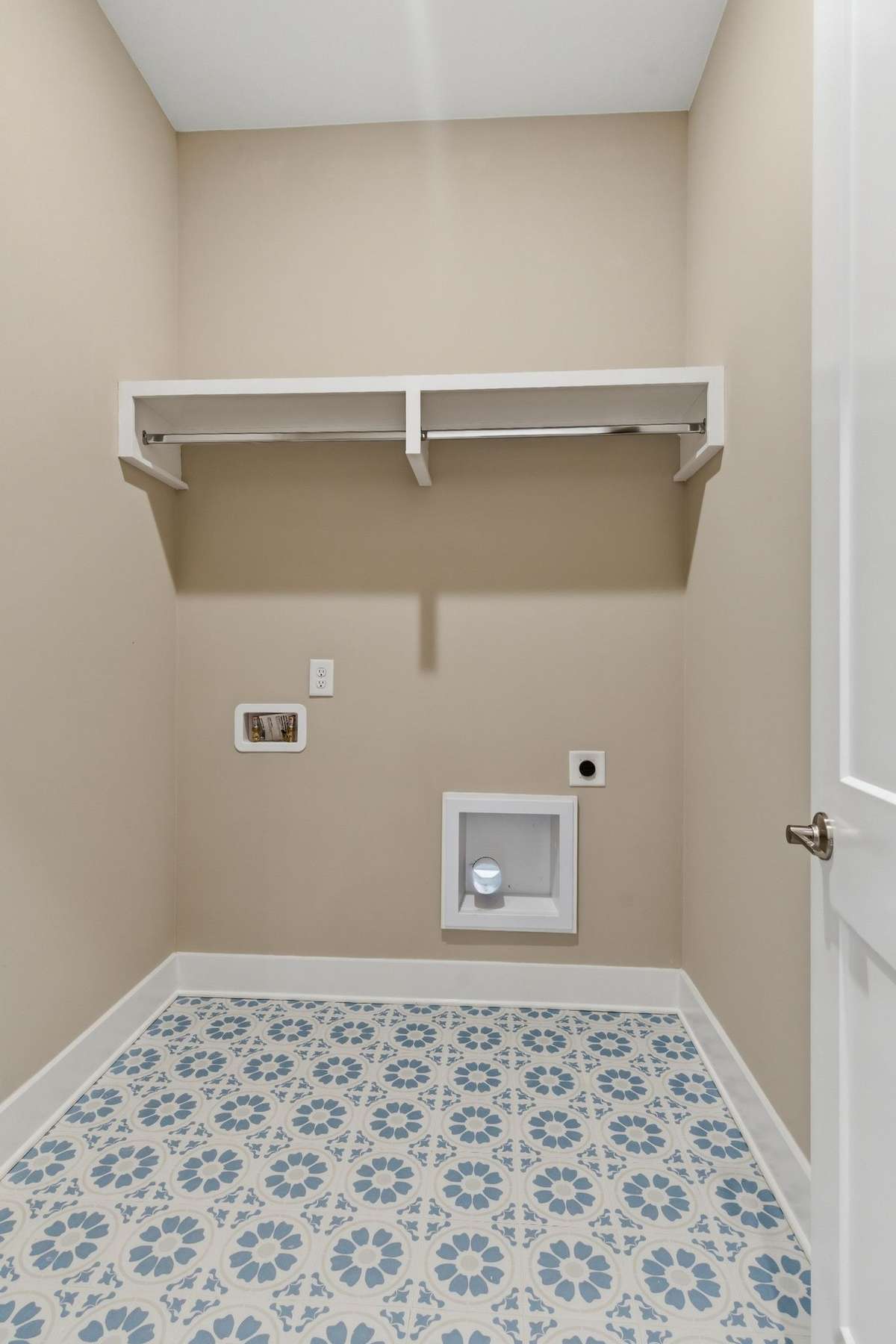 The laundry features beautiful tile and wood shelving above the washer/dryer area