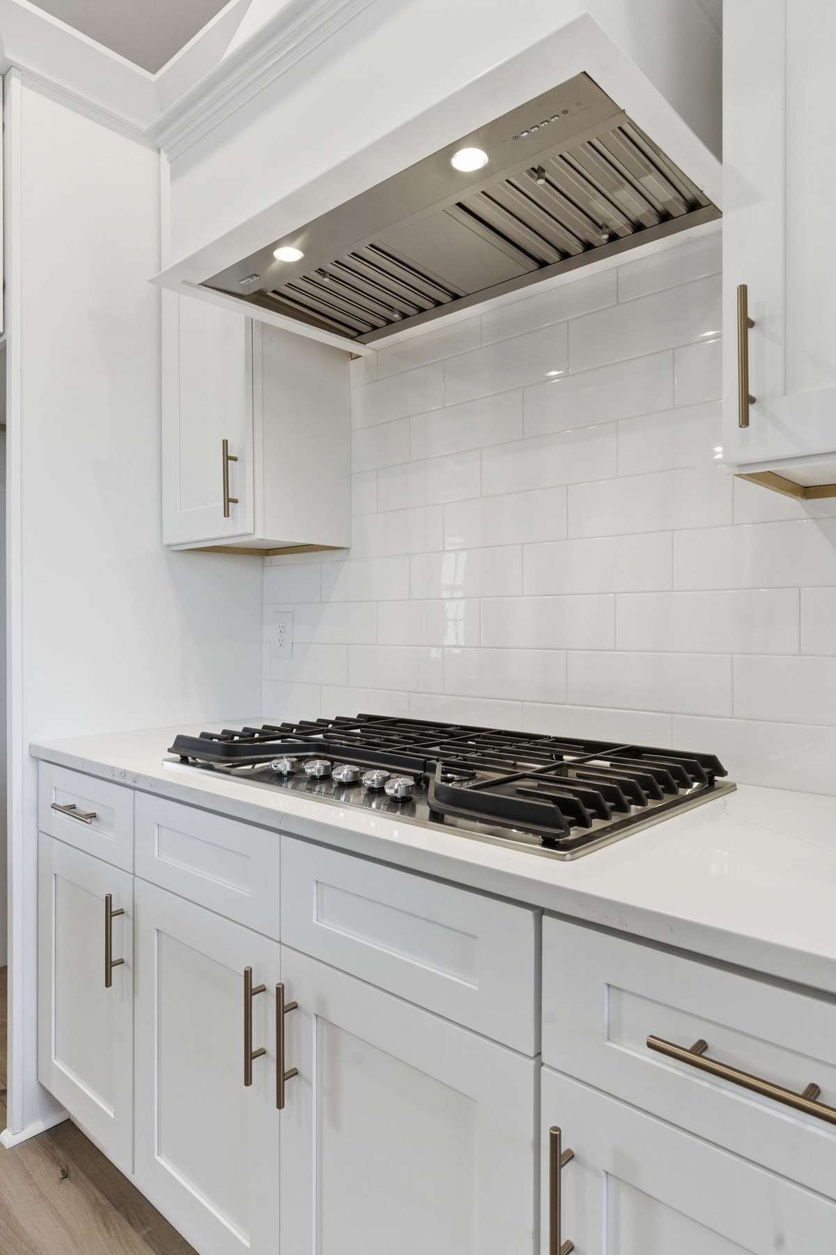 Upgraded gas cooktop and custom cabinet style vent hood.