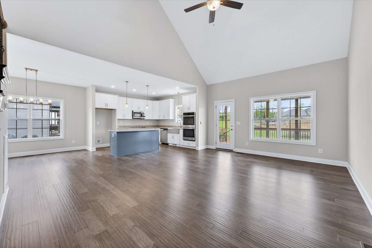 Expansive open-concept living room with vaulted ceilings and abundant natural light.